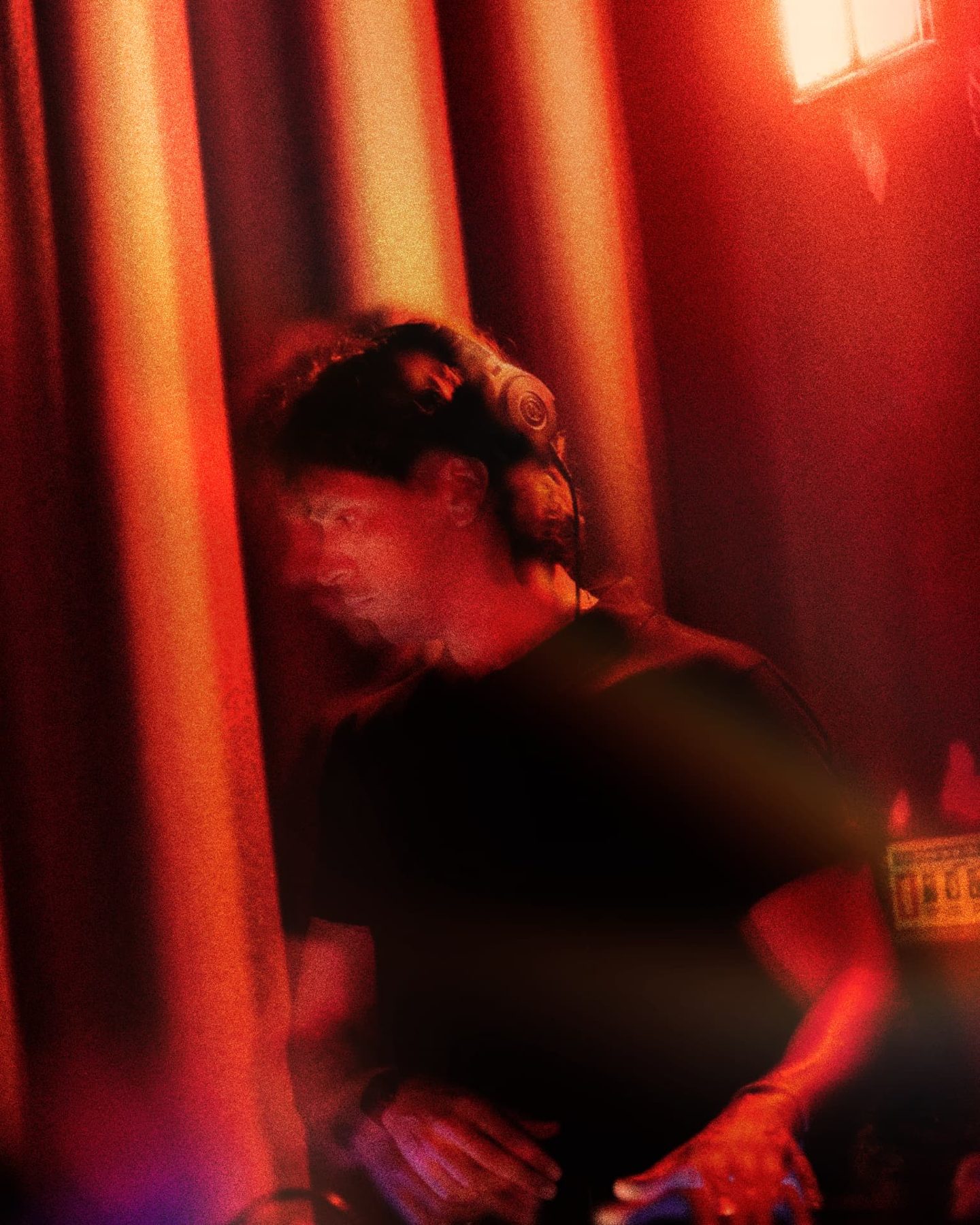 DJ with headphones performing in deep red light